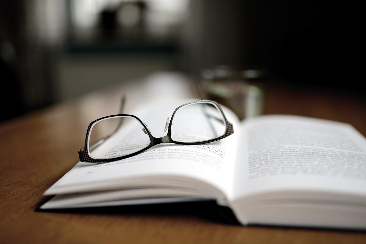 Open book with glasses on top